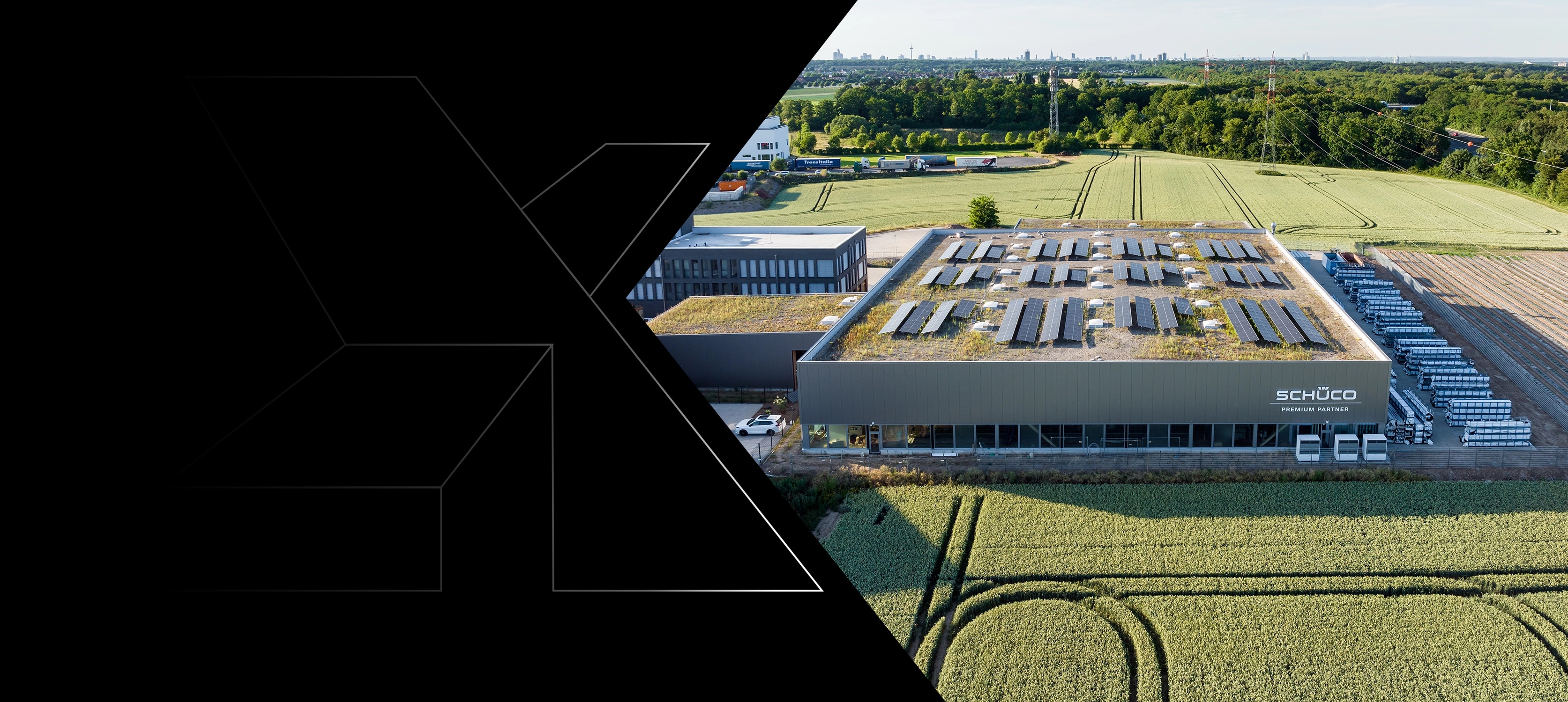 Aerial view of a timber commercial hall with a green roof and solar panels