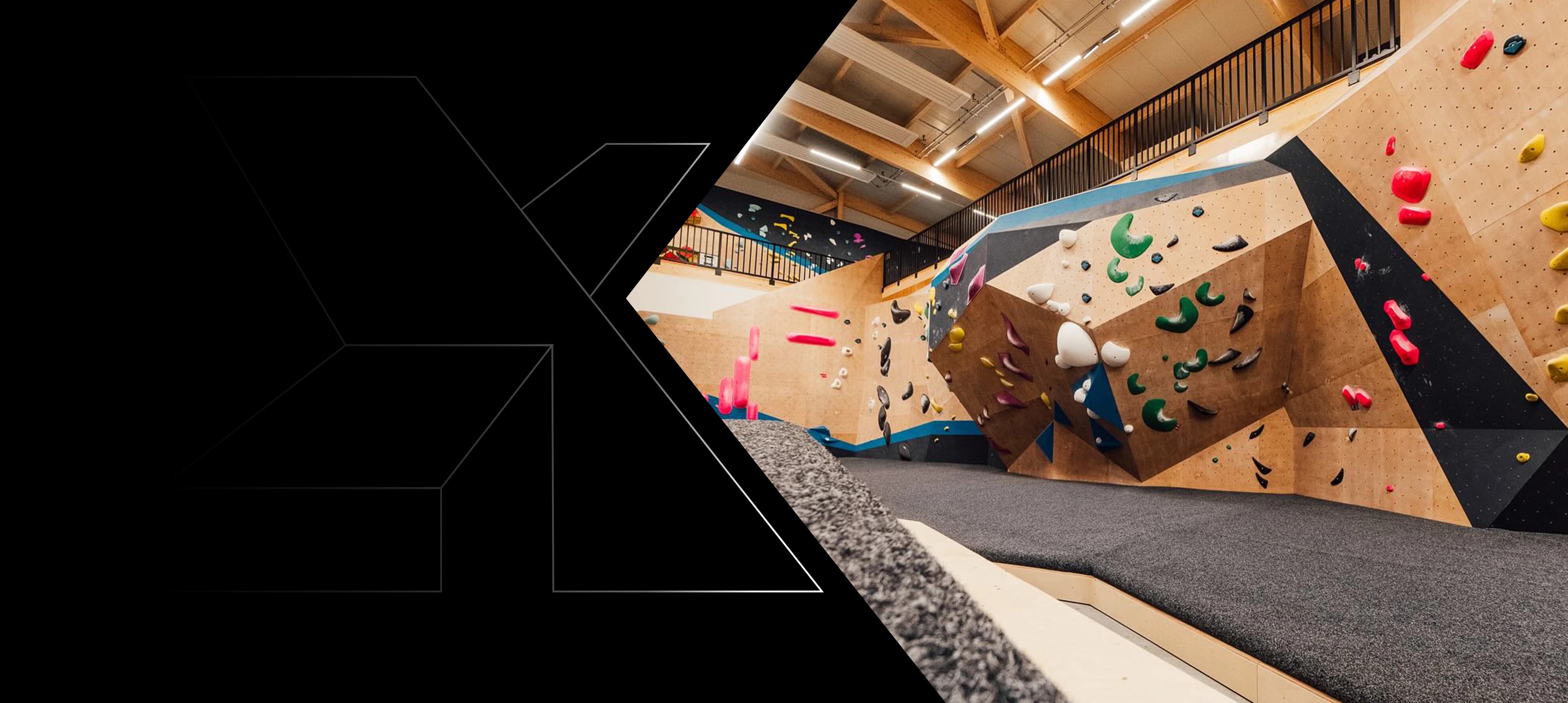 Timber bouldering hall with climbing walls under an exposed roof structure