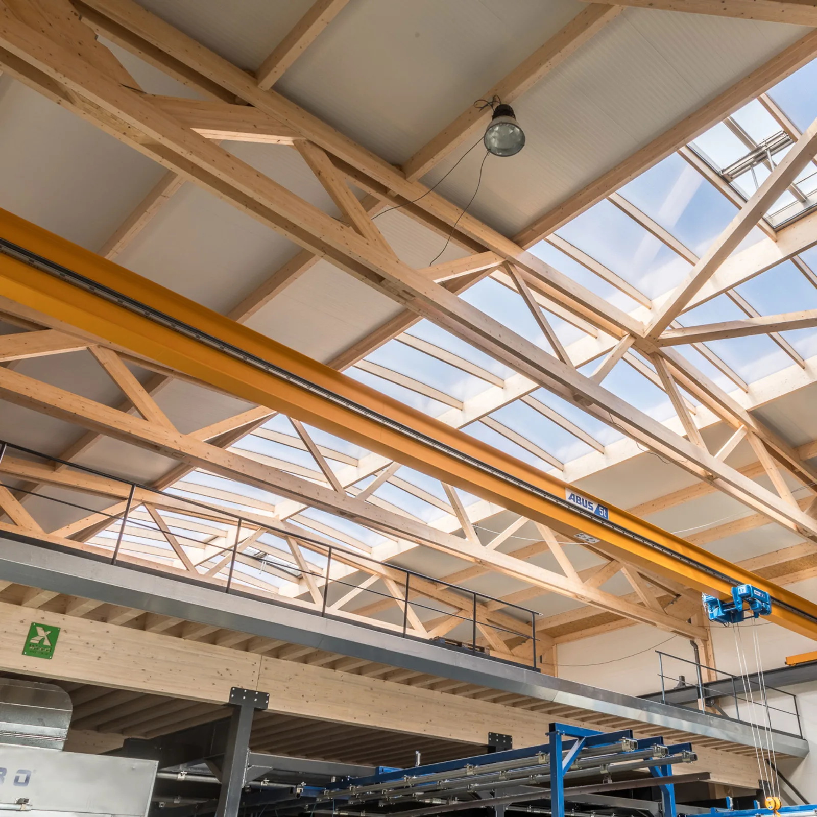 Timber trussed beam carrying a crane runway in an X-Wood® hall