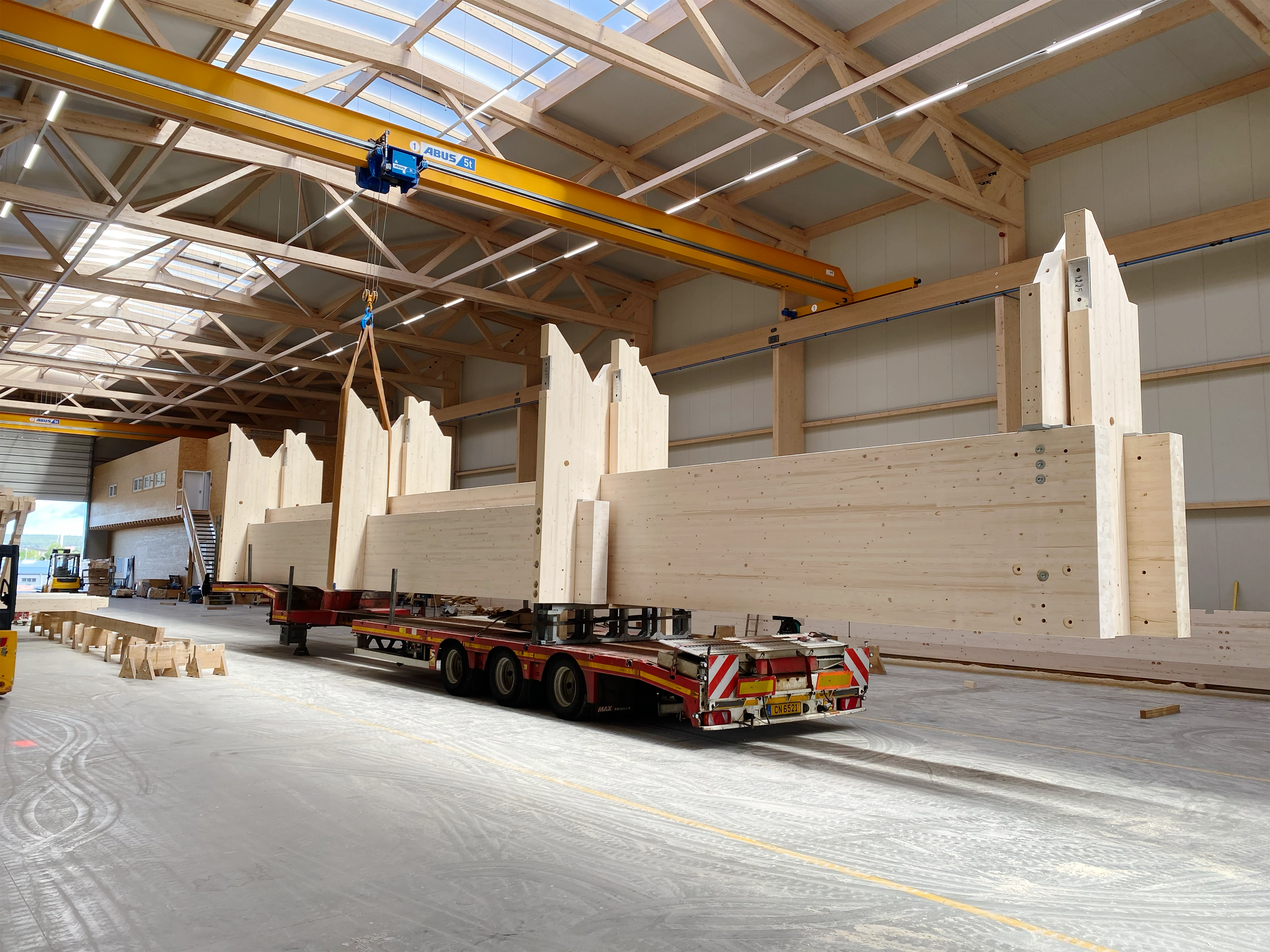 Prefabricated glulam beams on the low-loader in the X-Wood® production hall