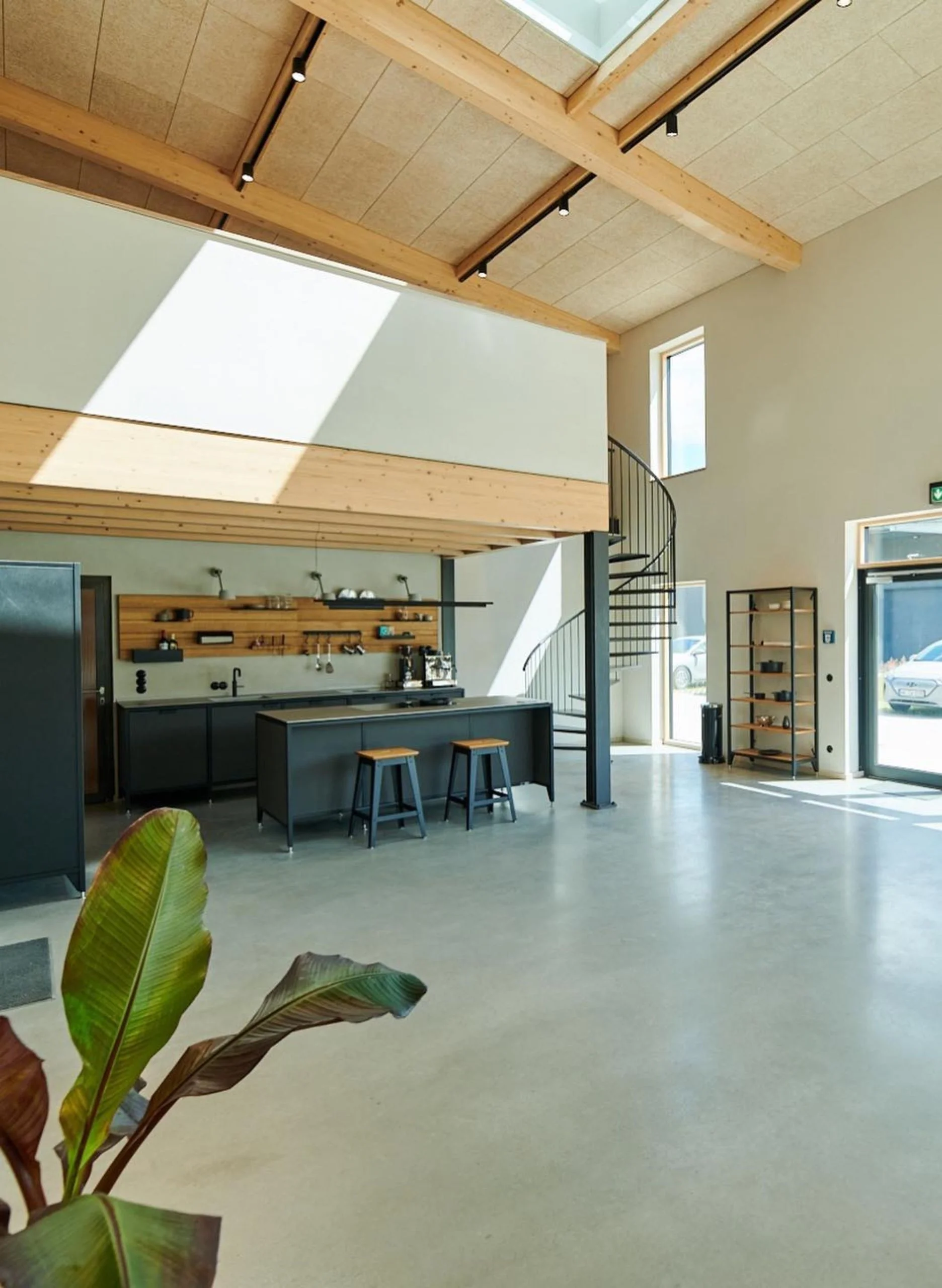 Heller Innenraum einer X-Wood®-Halle mit sichtbarer Holzdecke und Galerie