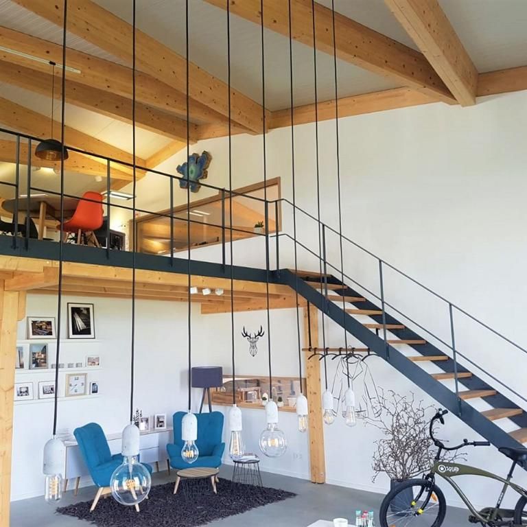 Zweigeschossiger Bürobereich in einer Holzhalle mit Empore, Stahltreppe und sichtbaren Holzbindern