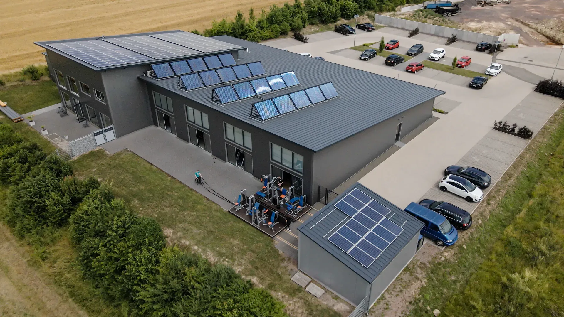 Aerial view of the Fitness-Treff in Orscholz, with photovoltaics and solar thermal on the roof and an outdoor training area.
