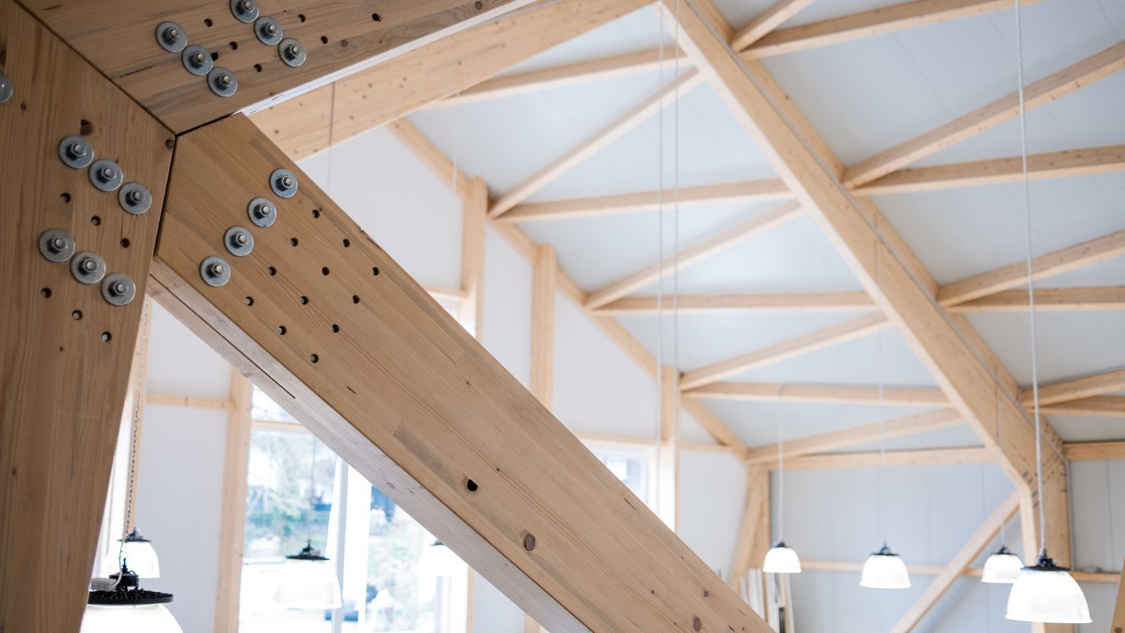 Holztragwerk mit sichtbaren Verbindungsschrauben in einer modernen Halle.